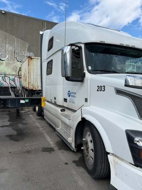 Flintstone Trucking white semi-truck parked in an industrial lot