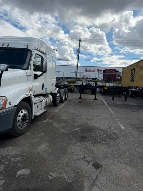 Flintstone Trucking semi truck and flatbed trailers in yard